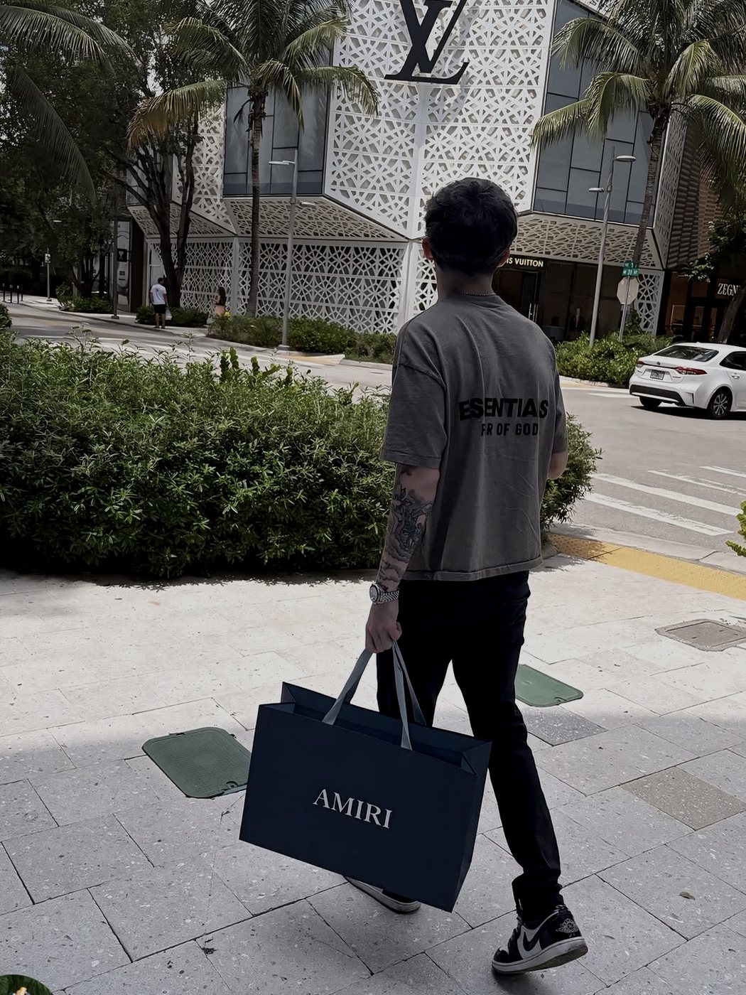 Travis walking past the Louis Vuitton store in Miami